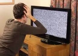 Person looking at a tv with a screen of static indicating no reception