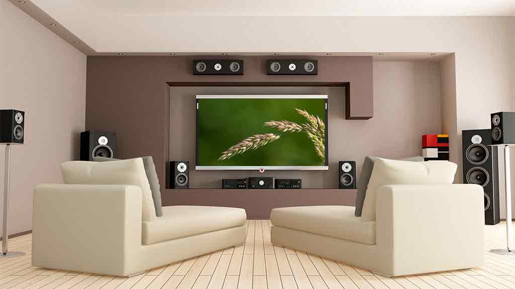 two lounge chairs in front of large tv with speakers above and below