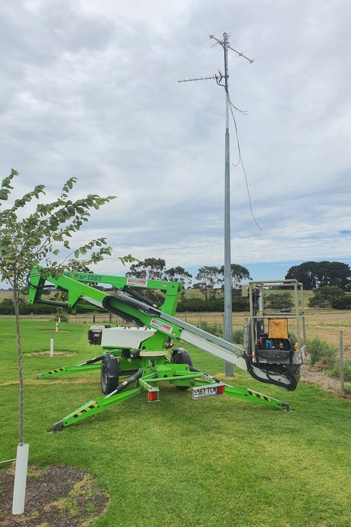 boom lift in front of free standing antenna
